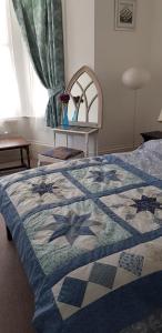 a bedroom with a bed with a quilt on it at Andorinho Sea View Apartment in Margate