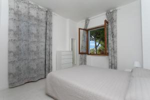 - une chambre blanche avec un lit et une fenêtre dans l'établissement M164 - Marcelli, nuovissimo trilocale con terrazzo, à Marcelli