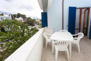 d'une table et de chaises blanches sur un balcon. dans l'établissement M164 - Marcelli, nuovissimo trilocale con terrazzo, à Marcelli