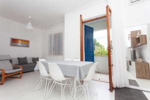 - un salon blanc avec une table et des chaises dans l'établissement M164 - Marcelli, nuovissimo trilocale con terrazzo, à Marcelli