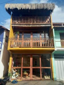 a building with a balcony on top of it at Pousada A Casinha in Icaraí