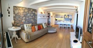 a living room with a couch and a stone wall at Villa Thea in Ancient Epidauros +52 photos