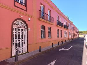 a red building with a gate on the side of a street at Holiday Home La Laguna Tenerife in Las Lagunas