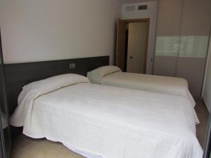 バルデロブレスにあるApartamentos Elvira Valderrobresのベッドルームに白いシーツが備わるベッド2台