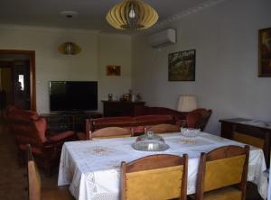 a living room with a table and a television at Dia's Holiday Home in Athens
