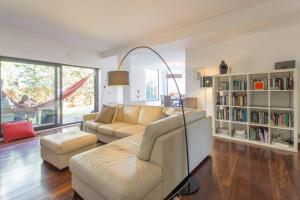 een woonkamer met een bank en een boekenplank bij Design Guincho Villa in Cascais