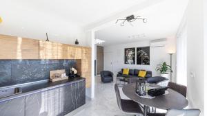 cocina y sala de estar con mesa y sofá en Hedonist-Luxury 2 bedroom apartment with private HOT TUB, garden and free parking, en Trogir