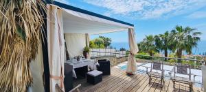 a patio with a table and chairs on a balcony at Luxury Sea View Villa Monet with Private Pool - Exclusive Retreat in Bordighera in Bordighera