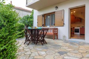 un patio con mesa y sillas frente a una casa en Small House with Garden & View, en Promírion
