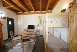 a room with a bunk bed and a table and chairs at Quinta Rosa Branca in Tavira