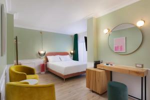 Pokój hotelowy z łóżkiem i lustrem w obiekcie De Cardo Hotel w Jerozolimie