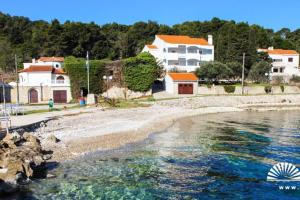 a view of a beach with houses and the water at Orhideja Apartment in Lukoran