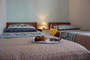 a tray of food and a glass of wine on a bed at Orhideja Apartment in Lukoran