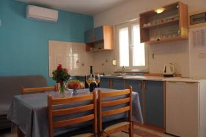 a kitchen with a table and a dining room at Orhideja Apartment in Lukoran