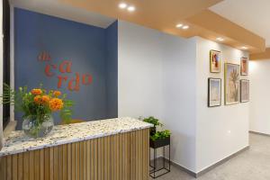 a blue wall with a vase of flowers on a counter at De Cardo Hotel in Jerusalem
