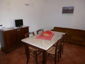a dining room with a table and a couch at Agritur Maso Fontane in Arco