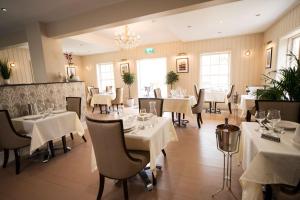 a restaurant with white tables and chairs and a chandelier at East Walls Hotel in Chichester