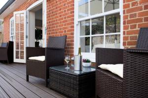 a patio with two chairs and a table with a wine glass at East Walls Hotel in Chichester