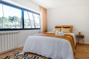 - une chambre avec un lit et une grande fenêtre dans l'établissement Amais Ofir Heart and Amais Ofir Soul - Twin Vilas, à Esposende