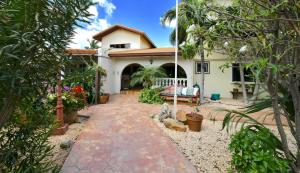 a large house with a large garden and trees at Wonders Boutique Hotel in Oranjestad