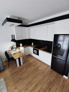 eine Küche mit einem Tisch und einem schwarzen Kühlschrank in der Unterkunft Apartamemt Królowej Jadwigi in Giżycko