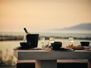 a table with glasses of wine on top of it at LaLune SeaSide Villa, Zante Zen By ThinkVilla in Kipseli