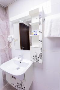 a white bathroom with a sink and a mirror at جلنار المدينة in Al Madinah