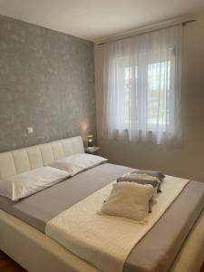a large bed in a bedroom with a window at Apartments Tony in Biograd na Moru +114 photos