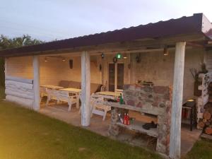 a patio with tables and a stone fireplace at Domki letniskowe u Bożeny in Krokowa