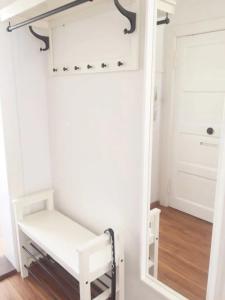 a small closet with a mirror and a white bench at Ferienwohnungen in der Uckermark in Schönermark