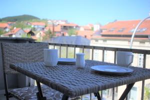 Wiklinowy stół z talerzem na balkonie w obiekcie Ecco Superior w mieście Novi Pazar