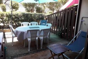 Appartement avec jardin Gruissan في جرويسان: طاولة وكراسي على فناء مع مظلة