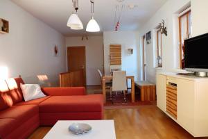 - un salon avec un canapé rouge et une table dans l'établissement Appartement Kaiserhof, à Bad Kleinkirchheim