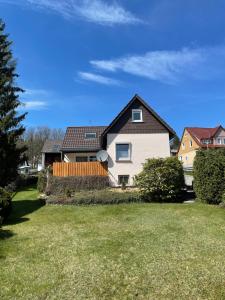 een wit huis met een zwart dak en een tuin bij Ferienhaus Bockswiese in Goslar