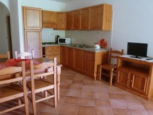 阿爾科的住宿－Agritur Maso Fontane，厨房配有木制橱柜、桌子和电视。