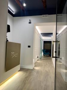 a hallway with a blue chair in a room at Toledo Boutique Rooms in Naples