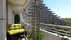 a chair on a balcony with a large building at Guestroom with wide view and pool near city side, 2nd guest with extra bed possible in Frankfurt/Main