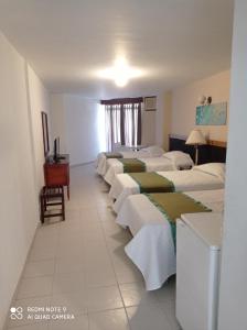 a row of beds in a hotel room at Hotel Betoma in Santa Marta