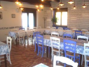 une salle à manger avec des tables et des chaises bleues dans l'établissement Agriturismo Lo Sgorzolo, à Pergola