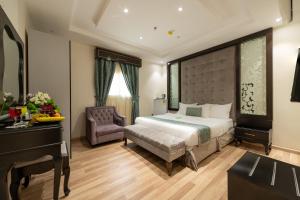 a bedroom with a bed and a desk and a chair at Holiday Plus Al Nuzha- هوليداي بلس النزهه in Jeddah