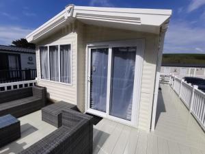 uma pequena casa com uma grande porta num deque em Premium Chalet at Newquay Away Resorts MV7 em Newquay