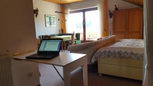 申瓦爾德的住宿－Ferienhaus Lucia, App.11，一间卧室配有一张床和一张桌子上的笔记本电脑