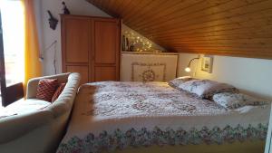 een slaapkamer met een bed met een bank erin bij Ferienhaus Lucia, App.11 in Schönwald