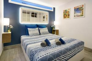 a bedroom with a large bed with blue walls at Modern Apt with Pool - Yumbo & Beach in Maspalomas