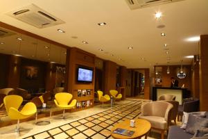 a waiting room with yellow chairs and a fireplace at Ela Hotel in Ardeşen