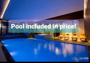 a swimming pool with chairs and a sign that reads pool included in price at Hotel Kocibelli POOL & SPA in Korçë