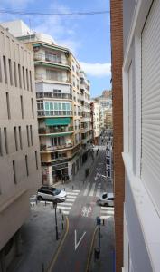 een uitzicht op een straat met auto's en gebouwen bij Apartamentos Navas GAM in Alicante