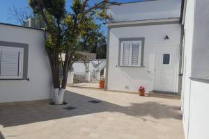 a white house with a tree next to a building at Casa vacanze Manuel, da Maruzzella in Procida