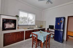 a kitchen with a table and a blue refrigerator at Casa vacanze Manuel, da Maruzzella in Procida