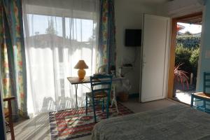 um quarto com uma cama, uma secretária e uma janela em l Annexe em Biscarrosse